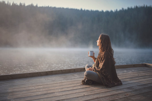 woman relaxing in nature with coffee meditating